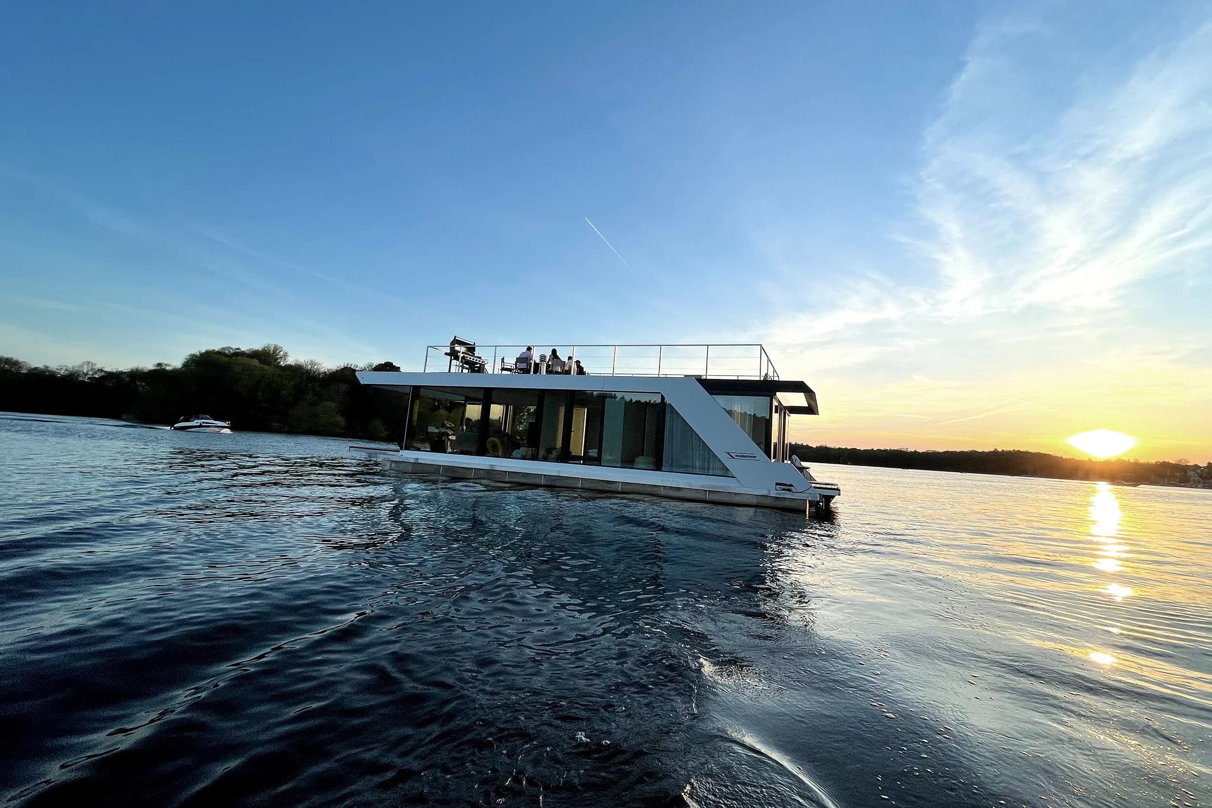 The Lakeside Loft Hausboot auf dem Wasser bei Sonnenuntergang